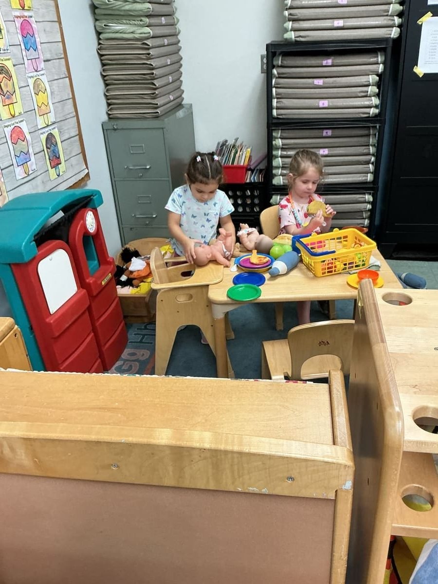 Teacher greeting a child at drop-off - childcare for families in Wilmington, MA