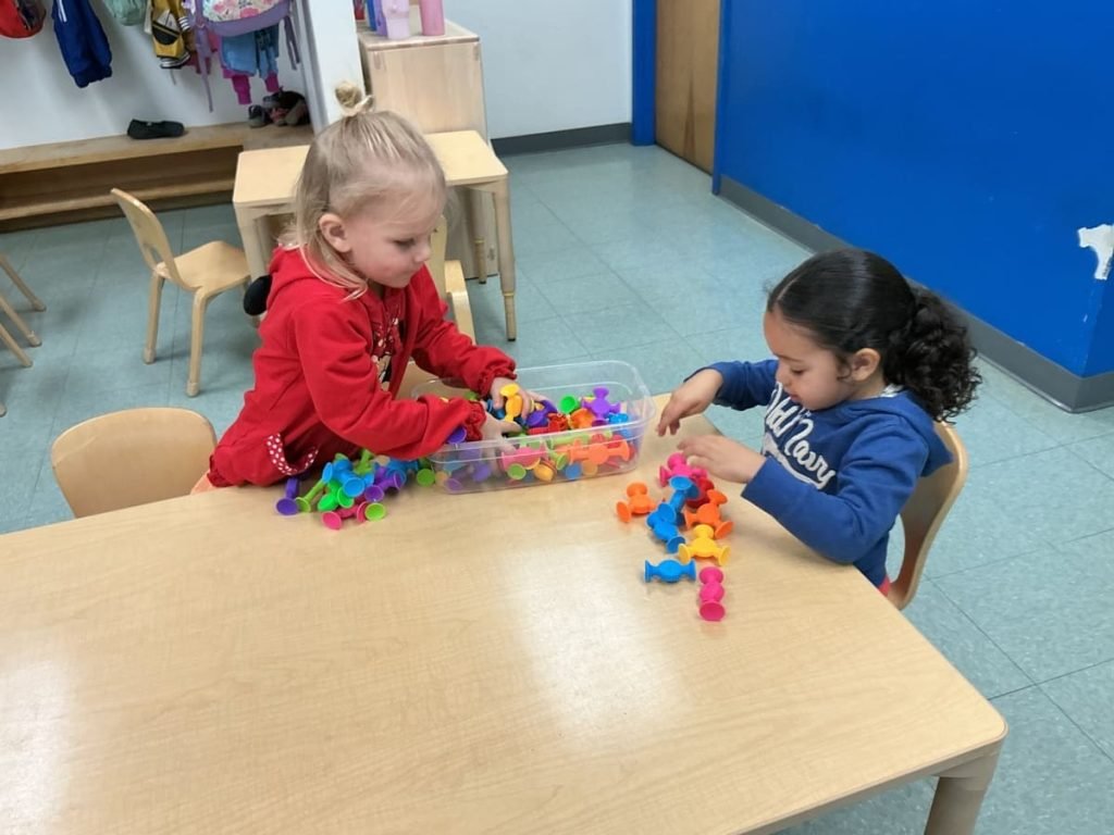 Preschoolers exploring an activity together at preschool in Wilmington, MA